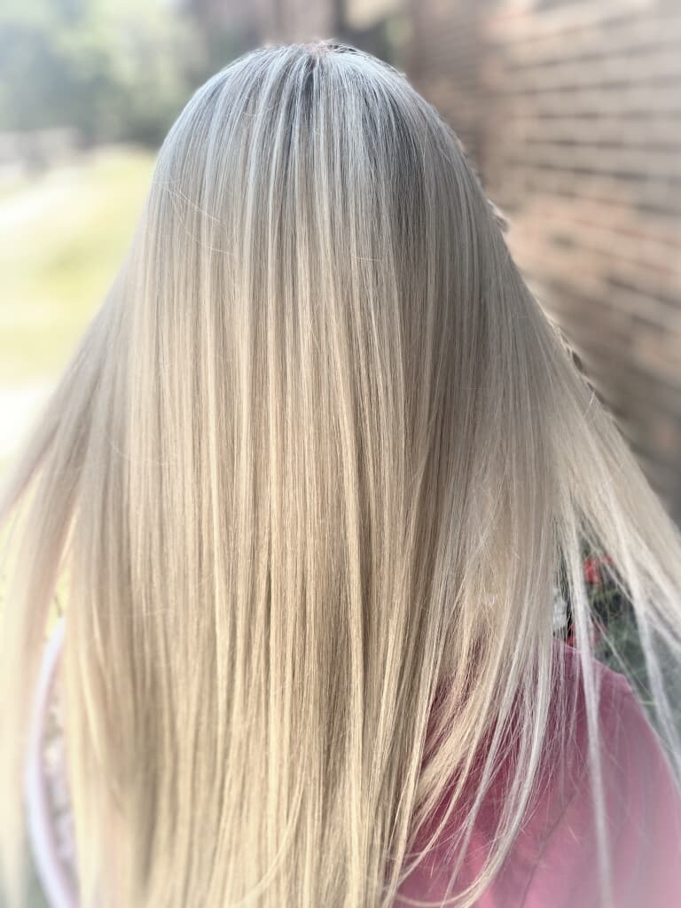 Platinum blonde color — icy ash blonde all-over color on long silky straight hair, back view at Divine Retreat salon
