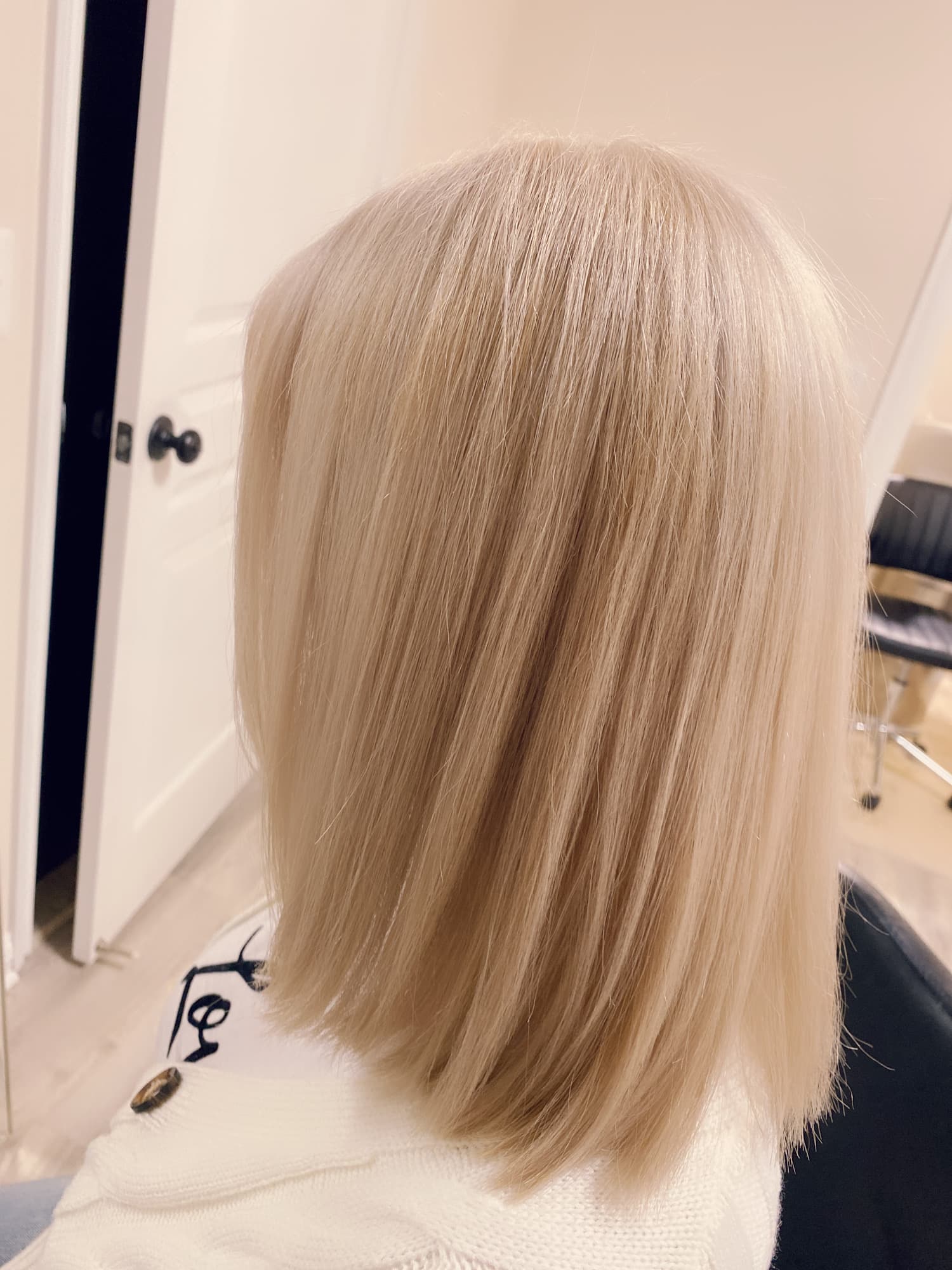 Platinum blonde color — icy cool-toned blonde on a straight medium-length lob with soft ends, back view at Divine Retreat salon