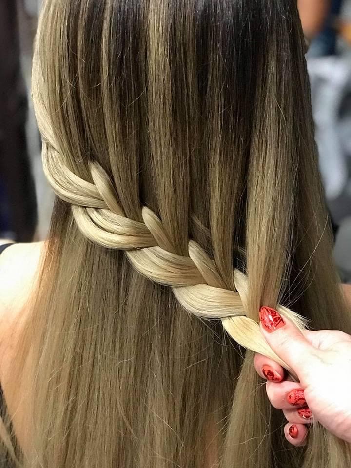 Balayage with braid styling — natural brunette-to-golden blonde balayage showcased in a loose side braid on long straight hair, back view at Divine Retreat salon