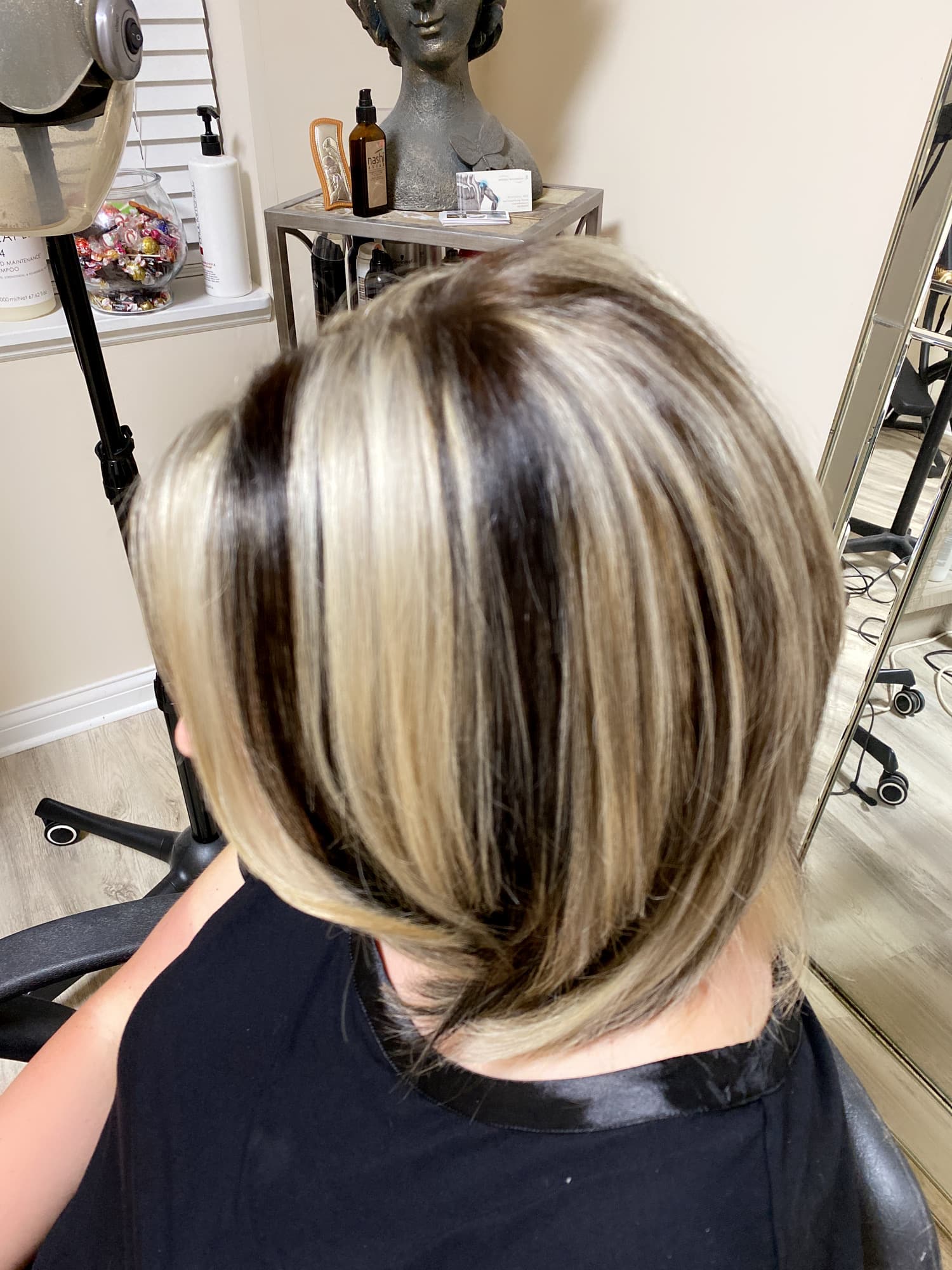 Bold chunky highlights — high-contrast platinum blonde highlights on a dark brunette base in a short layered bob, top-down back view at Divine Retreat salon